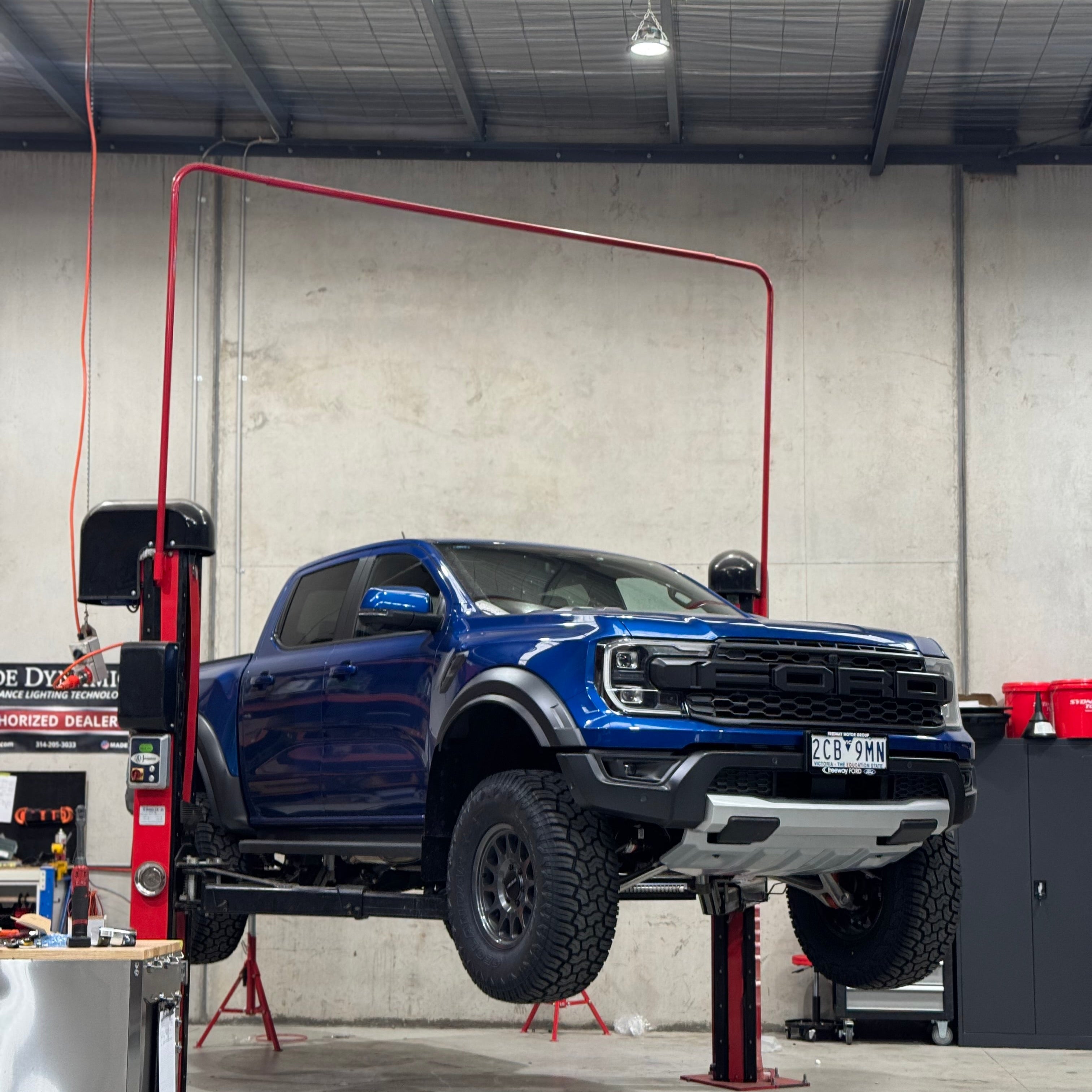 Blue truck on a lift in a garage